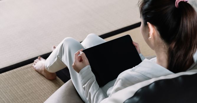 Above view of woman using smart tablet at home.