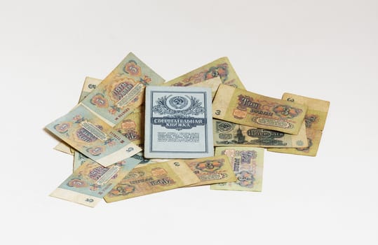 Soviet rubles and savings book of the Soviet era are on a light background

