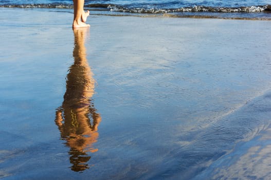 The female figure is reflected in the wet sand prebrezhnogo

