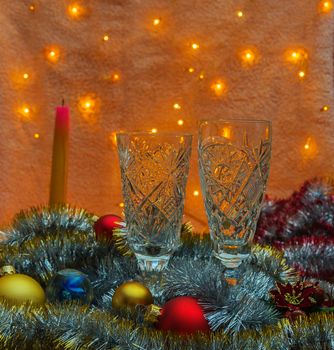 In the gloom there are two glasses of champagne, extinguished the candle and Christmas ornaments

