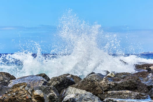 Waves breaking in splashes on the coastal rocks