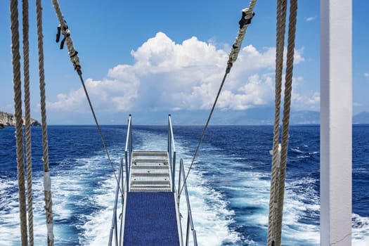 The ladder on the stern of the ship on the background of the ship's wake