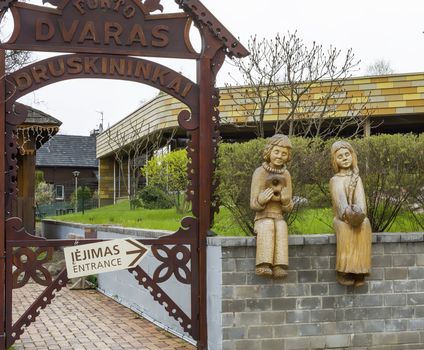 Two wooden figures of a boy and a girl, are installed at the entrance to the cafe in the Lithuanian city of Druskininkai