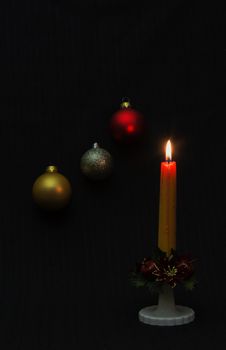 Candle and colorful balloons create a Christmas and New Year mood