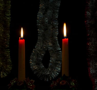 Two holiday candles burning in a romantic festive atmosphere
