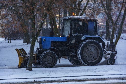 Traktor Balorus rensar snö från trottoaren under snöfall
