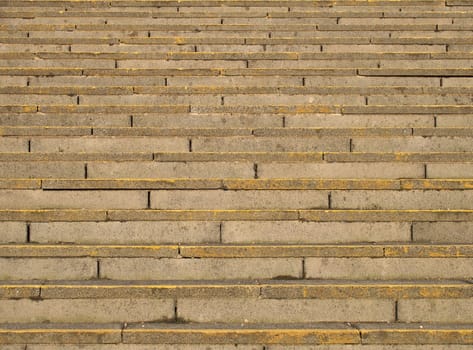 full frame image of old rough concrete stairs with rows of steps in perspective and traces of yellow paint