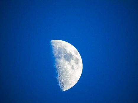 Liguria, Italy - 07/22/2020: Beautiful photography of the moonlight in the different phases with different colours. Black sky and little stars in the background.