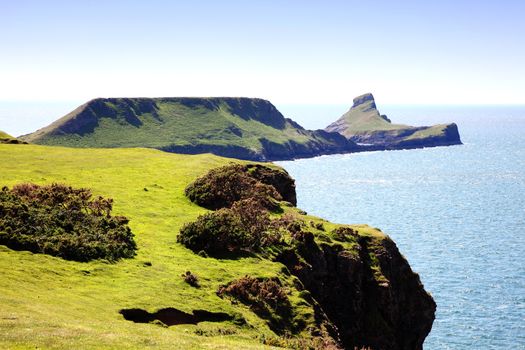 Worm's Head as seen from Rhossili Bay on the Gower Peninsular West Glamorgan Wales UK a popular Welsh coastline landmark attraction for a visitor travel destination of outstanding beauty stock photo