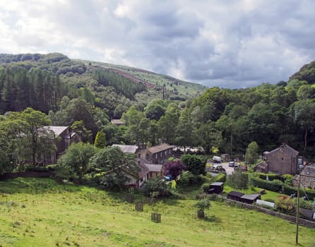 the small village of cragg vale in west yorkshire surrounded by pennine hills and trees