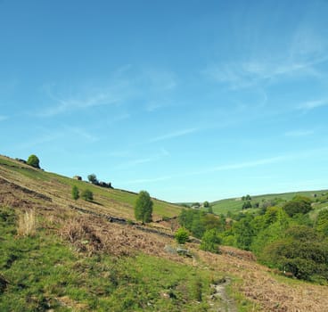 hilly green fields with grass covered pasture and old stone farmhouses in the yorkshire dales at crimsworth near hardcastle crags