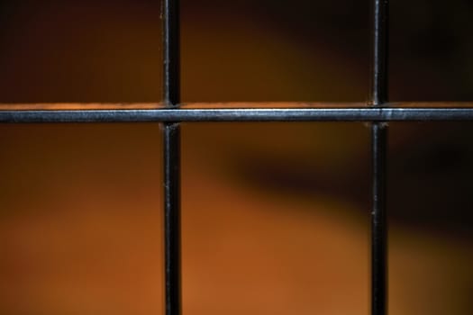 Close-up of an iron grille against a brown background