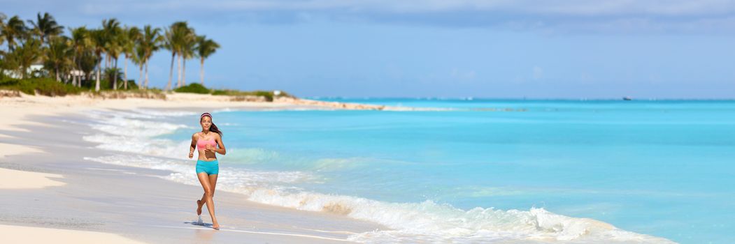 Healthy active woman running on beach banner panorama. Runner on summer vacation destination jogging on morning run. FIt lifestyle.