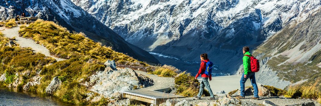 Hiking travel nature hikers in New Zealand banner. Panorama copyspace crop of tourists walking on Sealy Tarns trail and Mueller Hut route with Mount Cook background landscape.