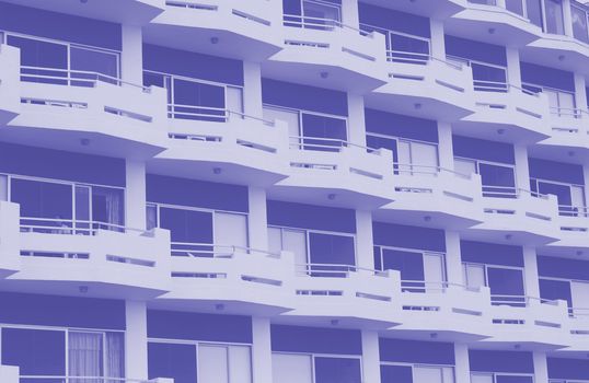 modern apartment building with white balconies and blue details with angular railings