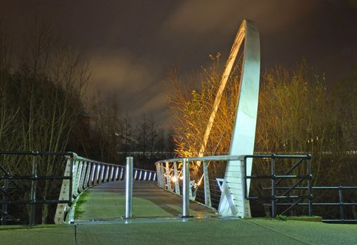 leeds, england - 19 january 2019: whitehall bridge a pedestrian footbridge crossing the river aire in leeds illuminated at night