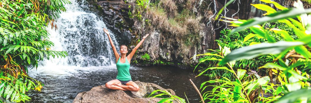 Yoga nature waterfall wellness retreat woman banner meditating. Meditation happy girl with open arms in serenity enjoying lush forest outdoors, mindfulness concept. Banner panorama crop.