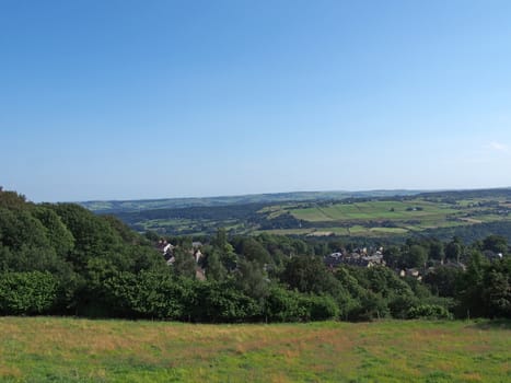 a panoramic view west yorkshire countryside with the village of warley surrounded by woodland and farmland with pennine hills in the distance