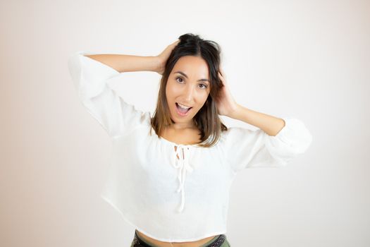 Beautiful young woman in white shirt surprised