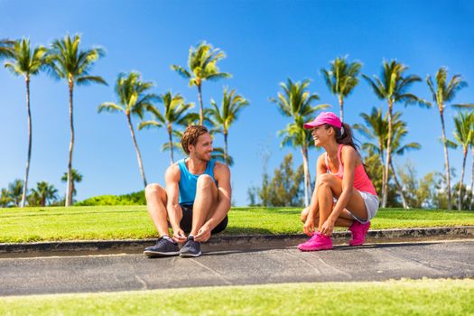 Runners tying running shoes getting ready to run. Runner woman and athlete man lacing shoe laces. Healthy lifestyle jogging motivation, happy healthy people.