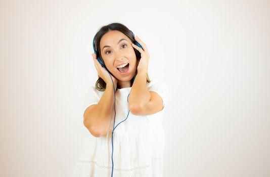 Beautiful woman in white dress with headphones