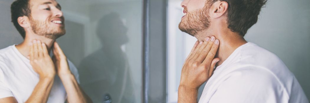 Man touching neck looking in mirror in home bathroom. Body care panoramic banner.