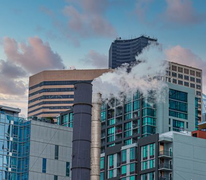 Steam from Smokestack in front of modern buildings in Seattle