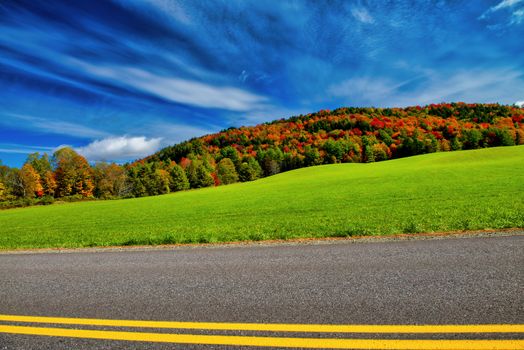 Road across New England countryside in foliage season, USA,