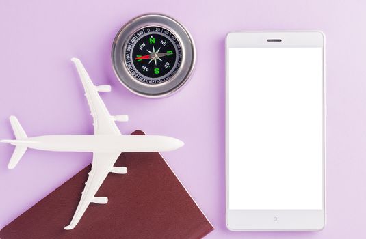 World Tourism Day, minimal toy model plane, compass and modern smart mobile phone blank screen, studio shot isolated on a purple background with copy space for text, holiday travel concept