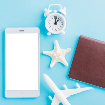 World Tourism Day, Top view of minimal model plane, airplane, starfish, alarm clock, compass and smartphone blank screen, studio shot isolated on blue background, accessory flight holiday concept