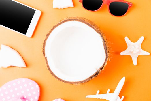 Happy coconuts day concept, fresh coconut, and summer accessories (model plane, sunglasses, smartphone, starfish and slippers), Beach tropical fruit trip journey and spring-summer holiday