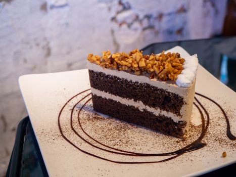 carrot cake with walnuts, prunes and dried apricots on a dark wood background.