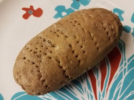 baked potato stabbed with holes from fork on plate