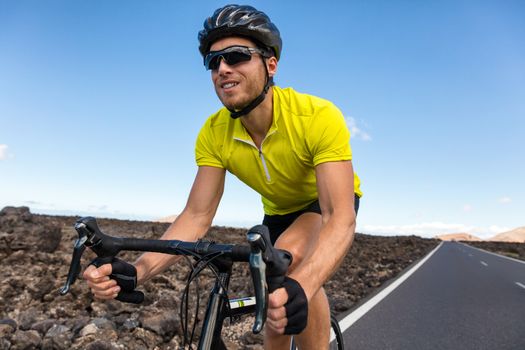 Cyclist man biking riding road bike training for triathlon. Biker on cardio workout on open road. Professional sports athlete living an active and healthy lifestyle.