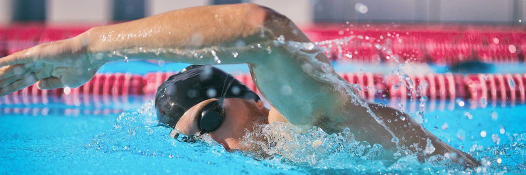 SPORTS and FITNESS concept sport athlete swimming in pool training cardio doing freestyle crawl technique for speed competition. Man swimmer in indoor stadium lane. Banner panorama.