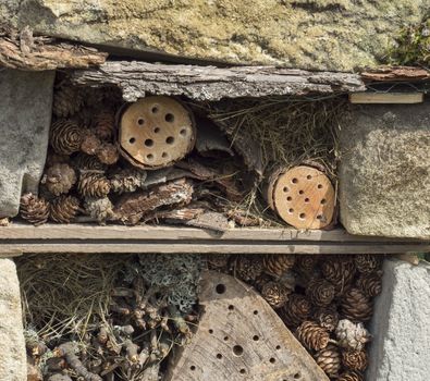 Home made insect hotel decorative bug house from sandstone and wood, ladybird and bee home for butterfly hibernation and ecological gardening. Protection for insects concept