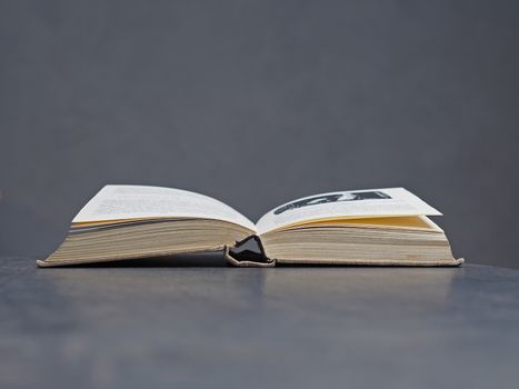 open old book with beige canvas binding, soft grey bacground - reading