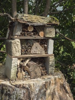 Home made insect hotel decorative bug house from sandstone and wood, ladybird and bee home for butterfly hibernation and ecological gardening. Protection for insects concept