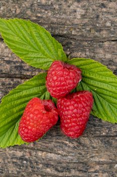 Ripe aromatic raspberries on a wooden background. Closeup.