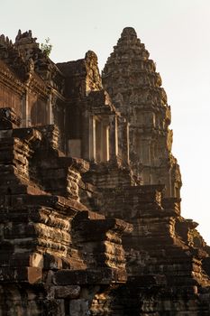 The temple complex of Angkor Watt, Cambodia, early morning sun looking up at towers and stairs. Warm coloured stones carved High quality photo