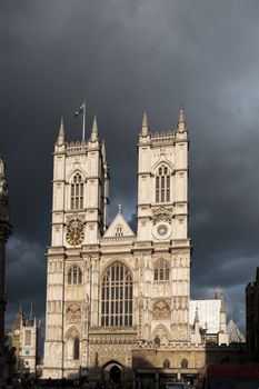 Front of abbey highlighted in late sun against a glowering slate grey doom laden sky