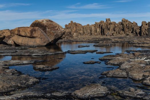 Bombo Headland Quarry Australia. Blue skies and reflections in water. HighBombo Headland Quarry Geological Site is a heritage-listed former quarry and now geological site at Princes Highway, Bombo, Municipality of Kiama, New South Wales, Australia. It is also known as Bombo quality photo