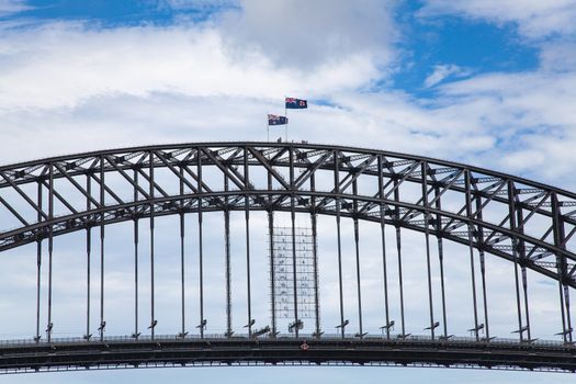 Sydney Harbour Bridge Sydney Harbour area Australia 12.12.2013 . National flags flying. Low angle looking up through bridge to blue sky with cloudsHigh quality photo