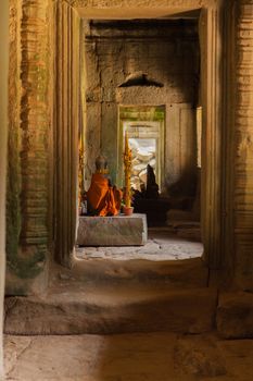 Important golden shrine in temple at Angkor Wat temples complex, shot through doorway with light illuminating the shrine. High quality photo