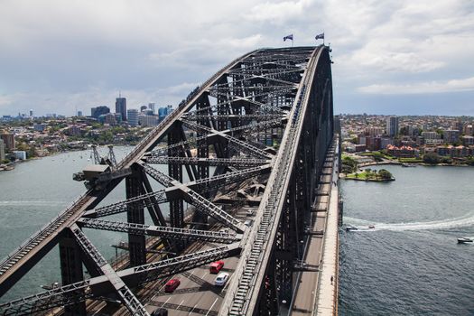 Sydney harbour with bridge structure in foreground. dramatic and unusual view of this landmark taken from one of the bridge pylons give a high angle view looking down the length of the bridgeHigh quality photo