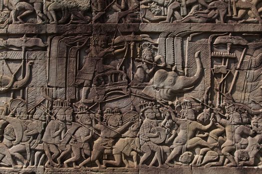 Angkor Watt, Cambodia is a temple complex with hundreds of temples decorated with sculptures, statues and wall reliefs. Many depict gods, kings and times of war. The are shot with side lighting giving texture and details to the subjects wall relief depicting ancient wars. High quality photo