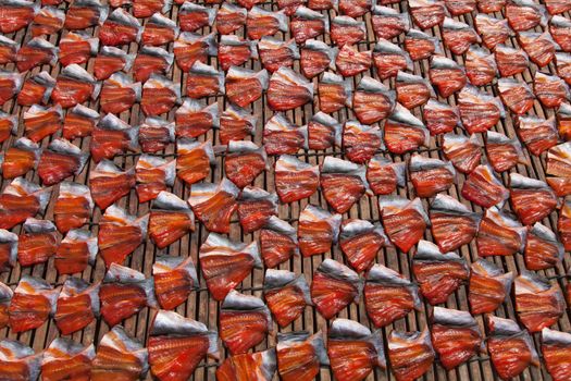 Fish drying in the sun at Phsar Prohok, The Fish Paste Market, Battambang where fish-paste is made, a staple condiment in Cambodia and Vietnam. The fish is gutted and cleaned and laid out in patterns of red and silver. High quality photo