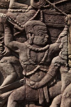 Angkor Watt, Cambodia is a temple complex with hundreds of temples decorated with sculptures, statues and wall reliefs. Many depict gods, kings and times of war. The are shot with side lighting giving texture and details to the subjects wall relief depicting ancient wars. High quality photo