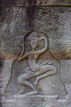 Angkor Watt, Cambodia is a temple complex with hundreds of temples decorated with sculptures, statues and wall reliefs. Many depict gods, kings and times of war. The are shot with side lighting giving texture and details to the subjects wall relief depicting ancient wars. High quality photo