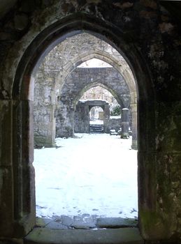 arches in doorways of a ruined medieval church in the snow in heptonstall west yorkshire